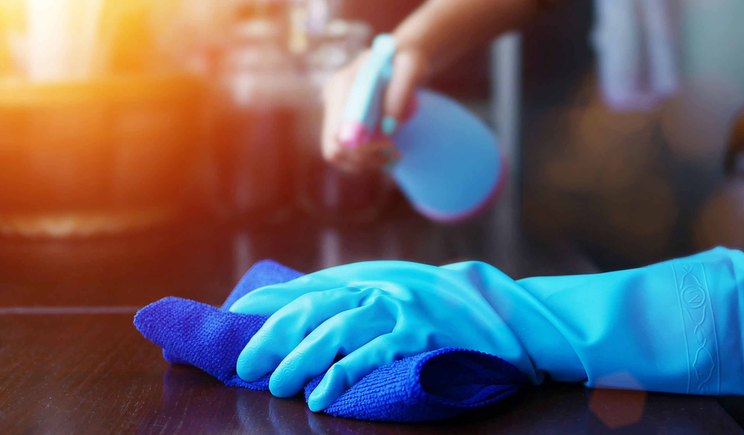 gloved hand with towel cleaning surface